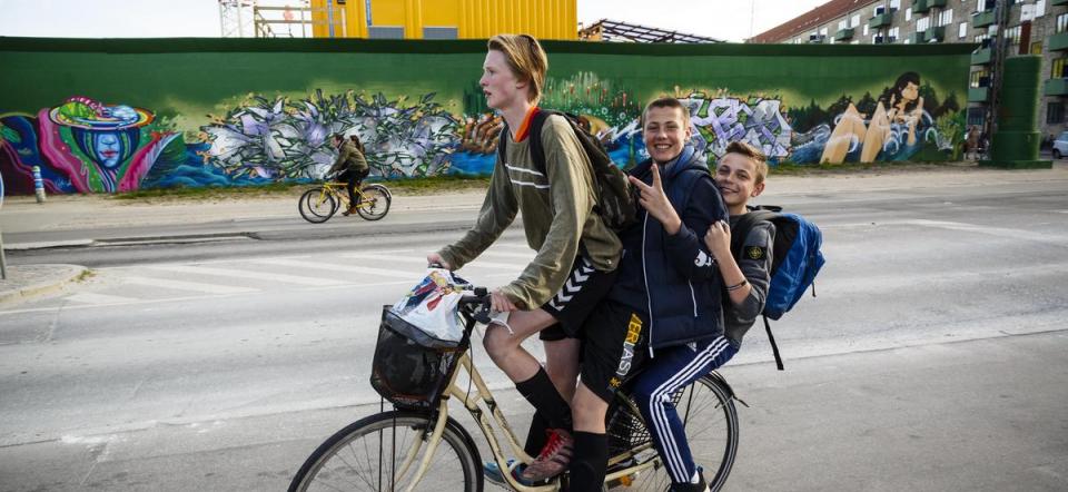 Three teenagers on a bike.