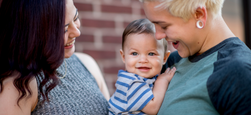 Two women holding a child.