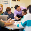 Diverse students and a teacher at a table studying. 